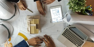 一组建筑师与建筑师模型讨论技术图纸
