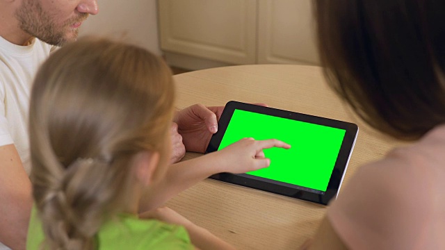 幸福的家庭使用平板电脑上的应用程序与预按键绿色触摸屏