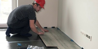 男性建筑商强化地板在新公寓