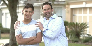 父亲和他十几岁的儿子站在屋外