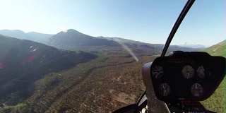 一架直升机飞过一个偏远的山谷