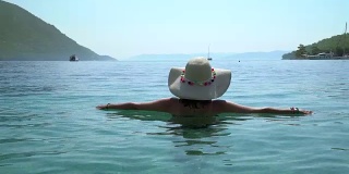 戴着帽子的中年妇女，在海边休息。Marmaris土耳其