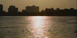 泰国曼谷，落日映照下的朝普拉亚河畔公寓剪影