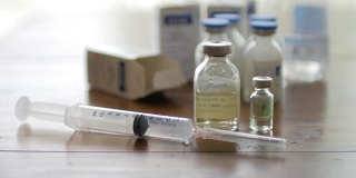 注射疫苗注射器与小瓶医疗近距离白色背景和木制桌子
