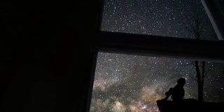 透过窗户看到孤独的女孩和银河