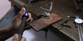 珠宝工匠打磨戒指的蜡模用粗平锉