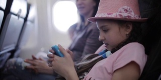 一家人在飞机上度假时，时间就在杂志和智能手机上度过