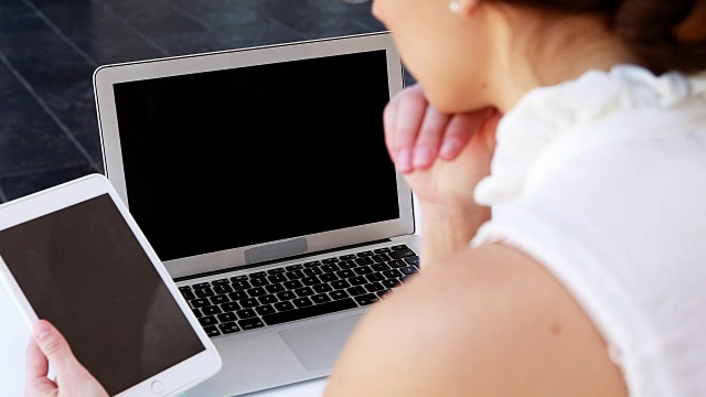 女性高管在4k办公桌前使用笔记本电脑和数字平板电脑