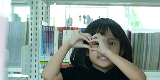亚洲女孩在图书馆，心标志