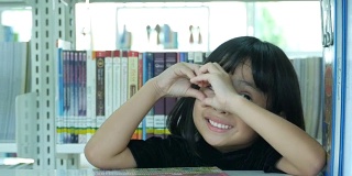 亚洲女孩在图书馆，心标志