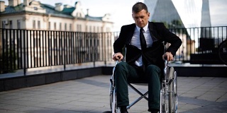 残疾人商人试图从户外轮椅上站起来