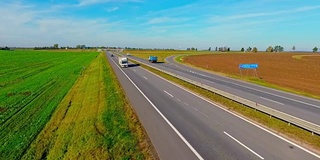 鸟瞰图卡车和汽车行驶在乡村道路上。高速公路上行驶的汽车