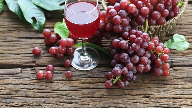 古老的木制背景上，一杯红酒和葡萄。有选择性的重点