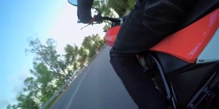 视频显示一名男子骑着一辆红色摩托车行驶在弯道上
