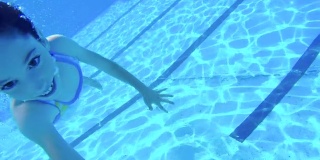 孩子们在游泳池里蹦蹦跳跳的水下镜头