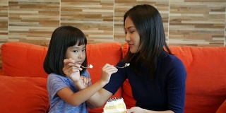 女孩和妈妈在咖啡店吃蛋糕