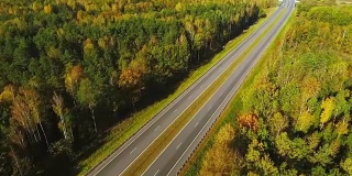 从上面看，汽车在高速公路上通过森林。高速公路路