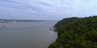 哈德逊河沿岸的风景和地平线上曼哈顿的远处景色。Palisades州际公园，新泽西州。无人机视频，慢速前进。