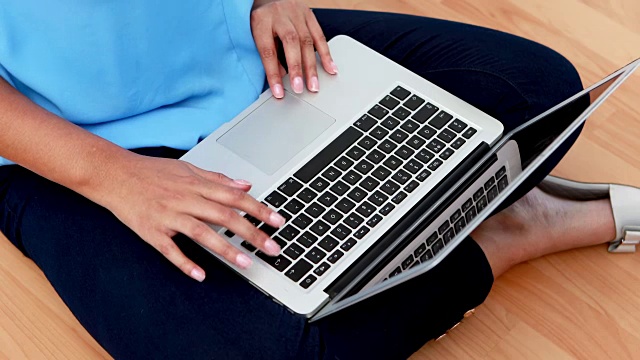 女性高管坐在木地板上使用笔记本电脑4k