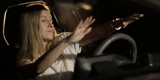 一个女人晚上在车里跳舞