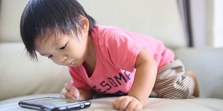 亚洲男婴使用手机。
