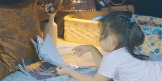 小女孩在帐篷里读儿童读物