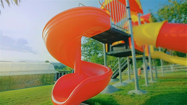 Happy Child Playing On A Slide At The Playground