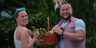 一个男人和一个年轻女人正在看篮子里的蔬菜