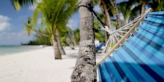 蓝色吊床在热带海滩上摇摆的特写