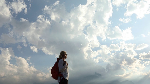 一位女性徒步旅行者向外眺望山景