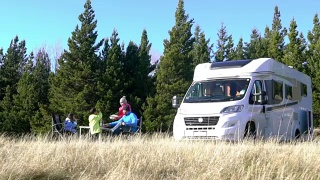 一个有两个孩子的家庭在新西兰露营，并把一辆房车停在他们旁边视频素材模板下载