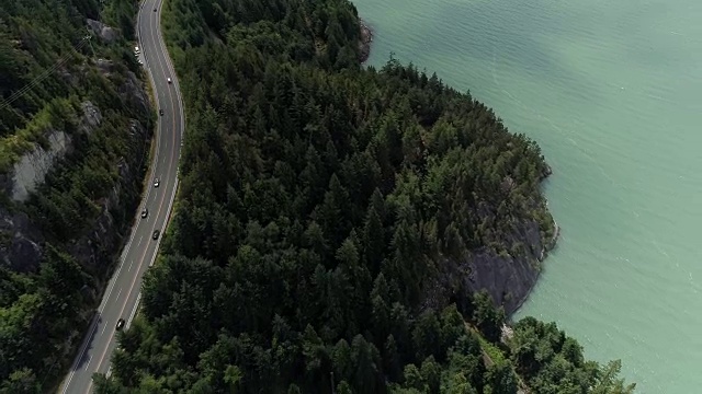 直升飞机在海洋悬崖沿海山区高速公路上飞过汽车