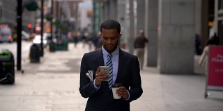 一个商人走在街上看他的智能手机