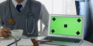 医生与笔记本电脑绿色屏幕