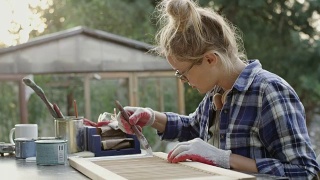 年轻女子在油漆旧家具视频素材模板下载