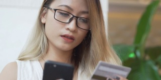 亚洲女性使用手机用信用卡进行网上购物