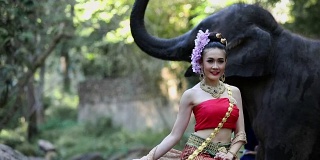 亚洲女人与大象在小溪，泰国清迈。