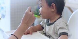 亚洲男婴(6-11个月)在家吃婴儿食品