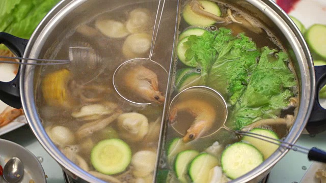从沸腾的汤中取出玉米、蘑菇和饺子。烹饪虾和沙拉