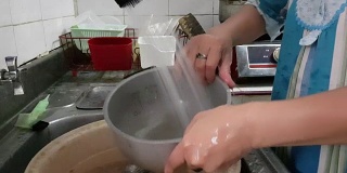 亚洲家庭主妇在家里洗厨具的超高清录像