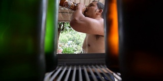 从冰箱里拿出啤酒的亚洲人