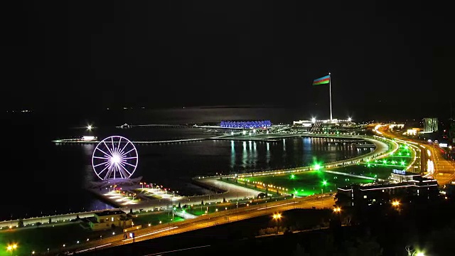 一个大城市的夜景，摩天轮的背景海和月球的路径。路上的交通。时间流逝