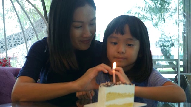女孩和妈妈一起享用着生日蛋糕，手打心牌