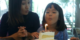 女孩和妈妈一起在咖啡店享用生日蛋糕