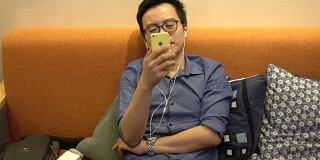 4k:年轻的亚洲商人通过智能手机与朋友facetime通话