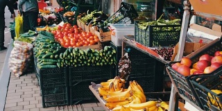 市场柜台上有很多新鲜蔬菜。买家会挑选新鲜的西红柿、土豆、辣椒、豆子、樱桃、香蕉。市场上的买方和卖方。人们选择食品