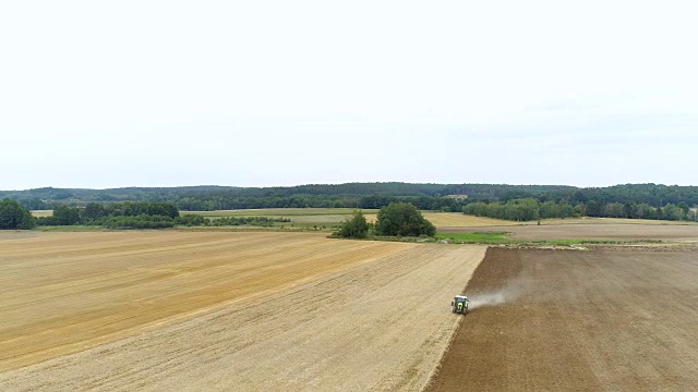 农用拖拉机在农田播种、耕种。