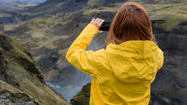 游客探索冰岛，拍摄它的峡谷