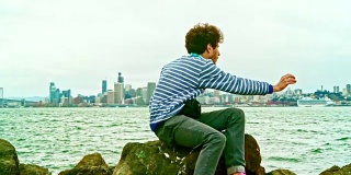 年轻的潮人在金银岛拍摄旧金山斯基林在旧金山的景色前。