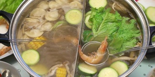 概念火锅亚洲美食。将虾分配到撇子中煮。妻子照顾丈夫
